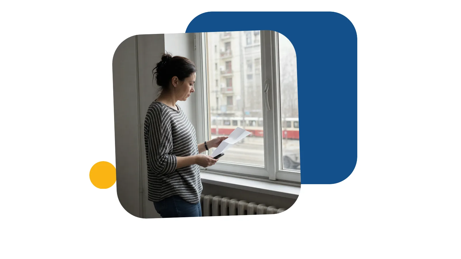 Жінка з телефоном біля вікна у європейському місті переглядає документи